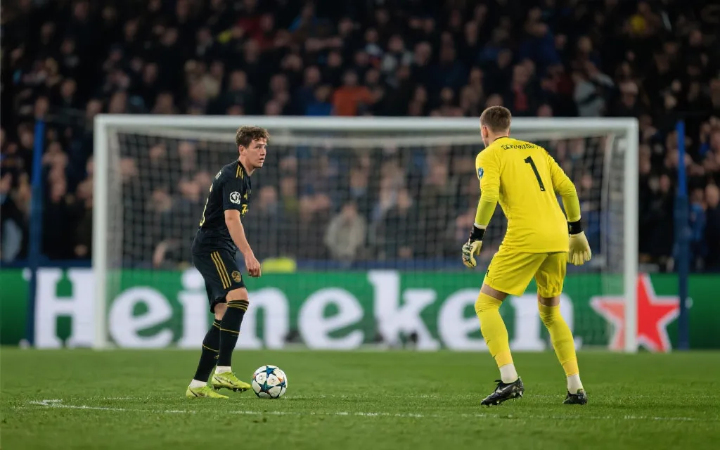 点球大战前球员与门将对峙，灯光与阴影下的紧张氛围